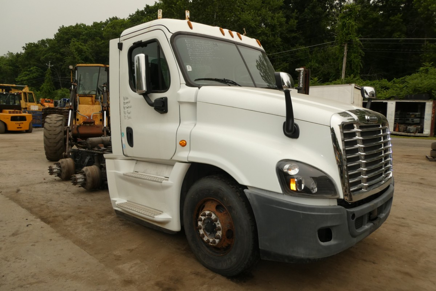 Freightliner Cascadia 125 truck cab in white, front-left view, with missing rear sleeper unit and exposed chassis.