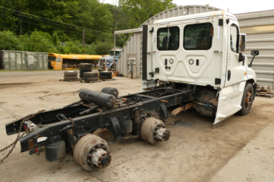 Freightliner Cascadia 125 truck chassis with rear axles exposed and cab intact, white cab and missing trailer