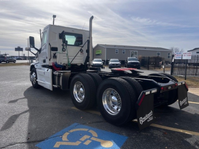 Conventional daycab truck chassis of a new 2026 Mack PR64T with dual rear axles, white cab, factory air cleaners, and chrome wheels.