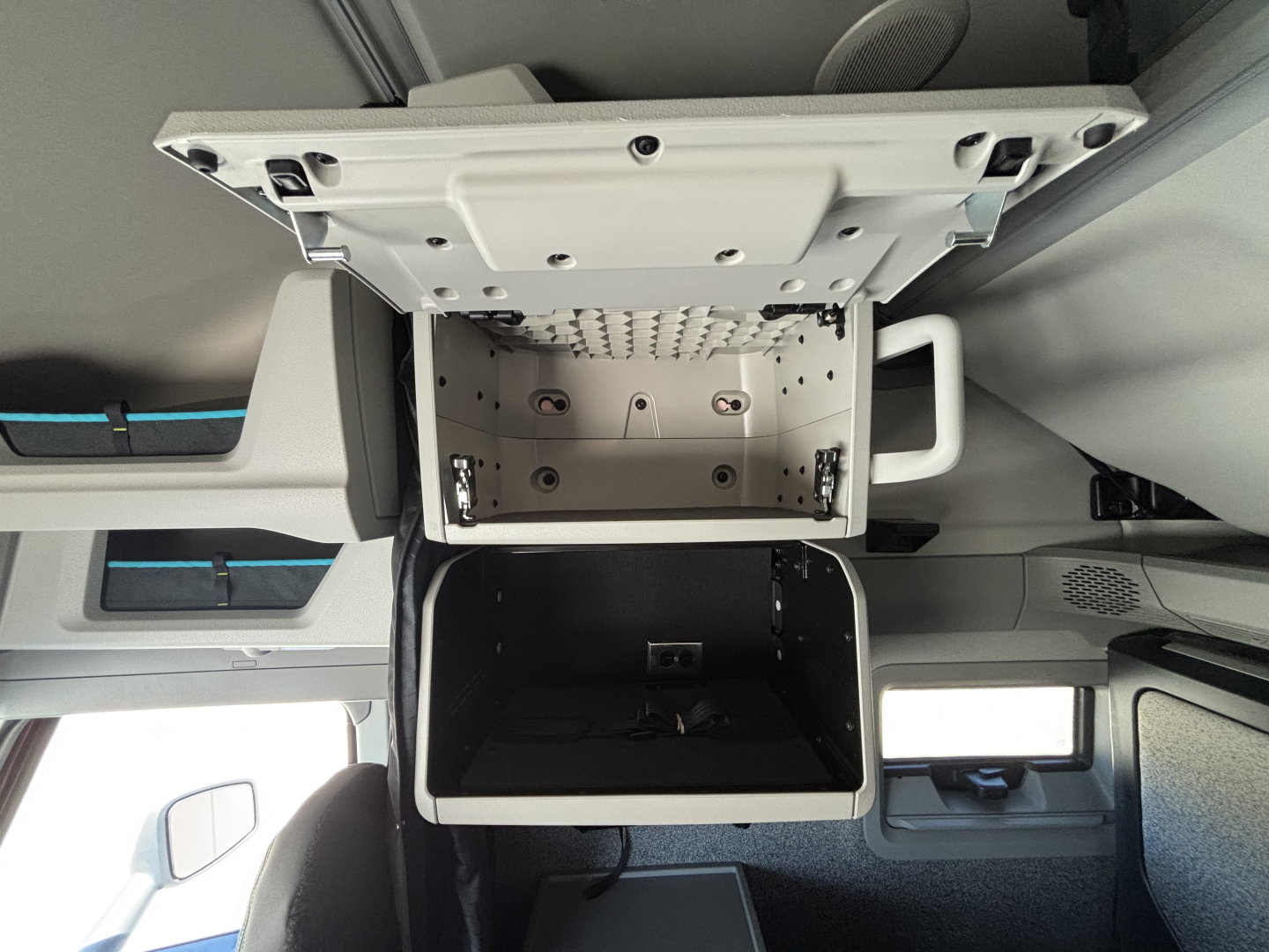 Volvo VNL cab interior showing overhead storage compartment open, internal mount panel and sleeper area visible.