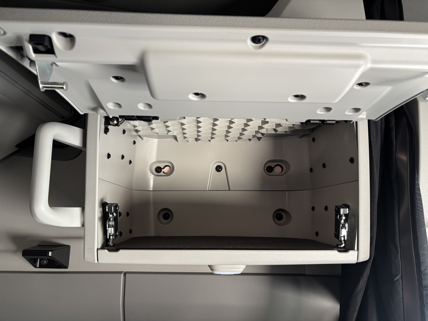 Volvo VNL64T860 truck cab interior showing open overhead storage compartment with metal hinges and latches.