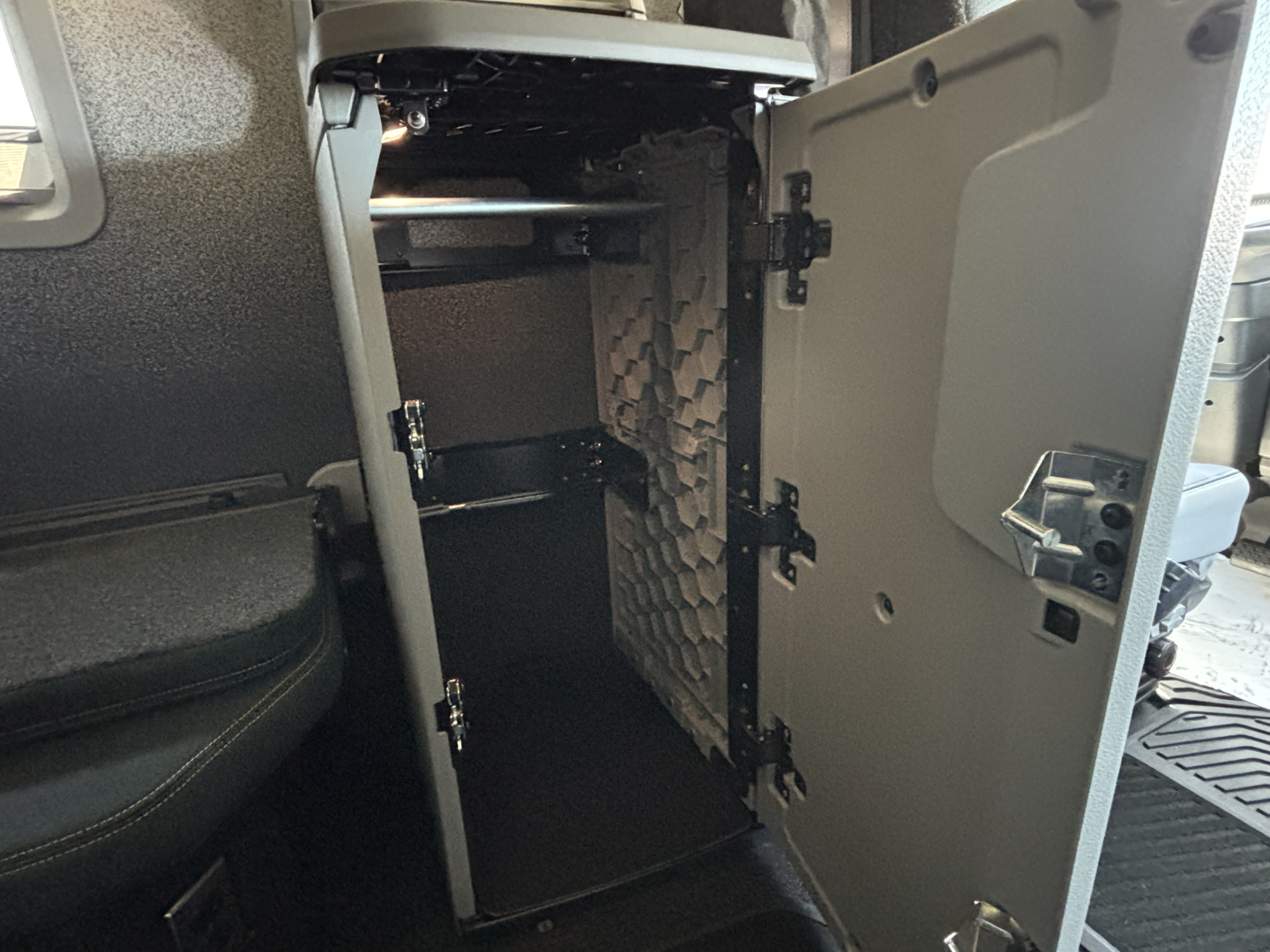 Volvo VNL64T860 sleeper cab interior storage cabinet open with shelves and toolbox area visible.