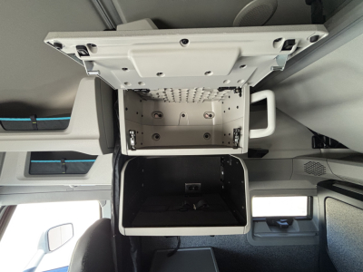 Volvo VNL cab interior showing overhead storage compartment open, internal mount panel and sleeper area visible.