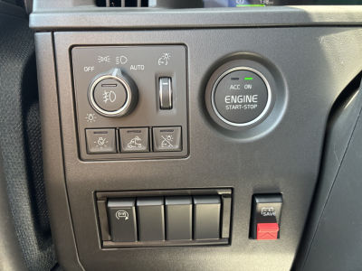Volvo VNL64T860 dashboard panel showing headlight controls and engine start-stop button with icons and switch group.