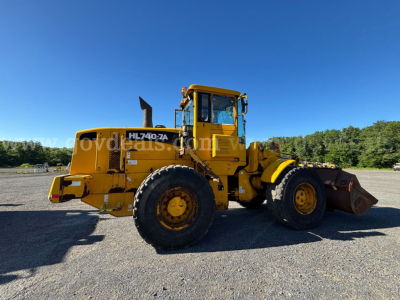 Hyundai HL740-2A wheel loader in service yellow, side profile, large front bucket, tires, and cab visible.