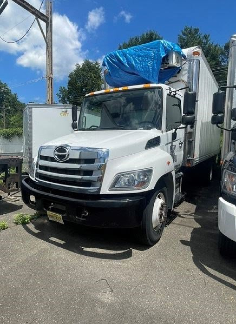 Hino 258/268 reefer truck front view with white cab and refrigerated box, blue tarp over top, stock number GH1028.