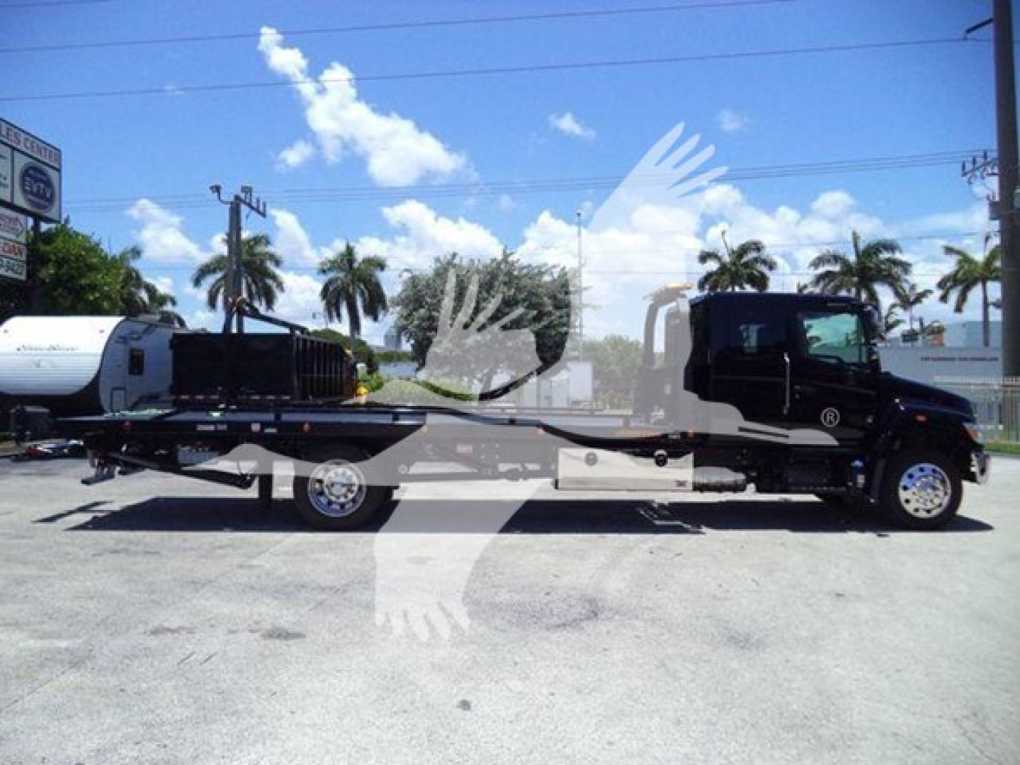 2026 Hino L6 rollback truck viewed from side with hydraulic rollback bed, chassis and cab in profile.