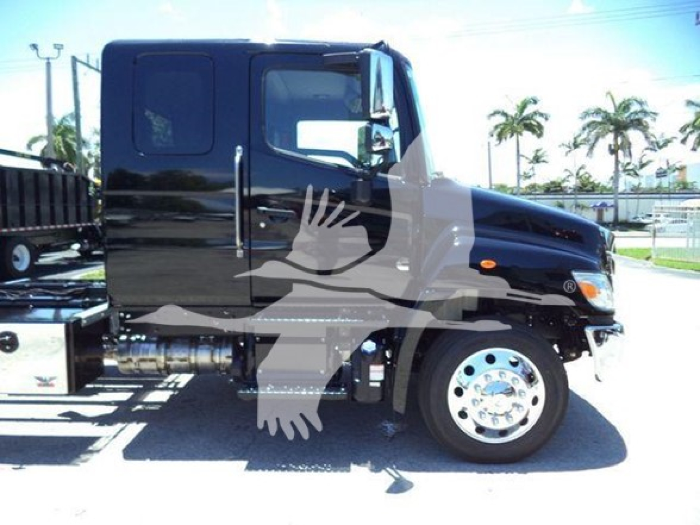 Truck side view showing cab and dual rear wheels with chrome rims; Hino-style front fascia; no visible text on the truck.