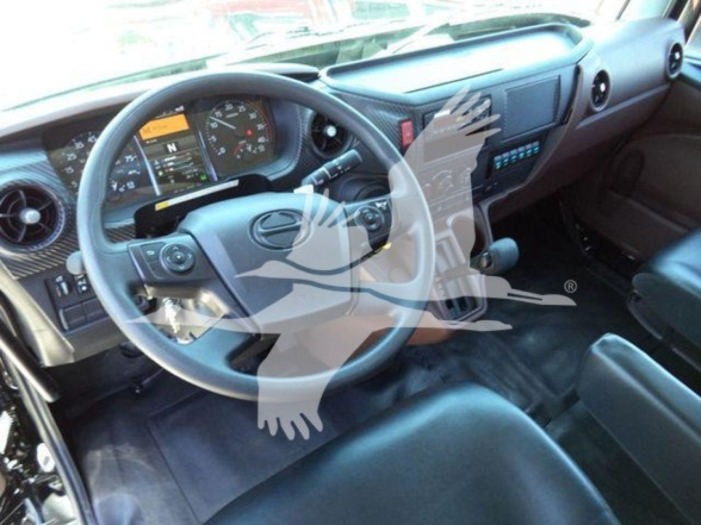 Truck cab interior showing steering wheel, dashboard gauges, and driver's seat in a new Hino L6 rollback truck.