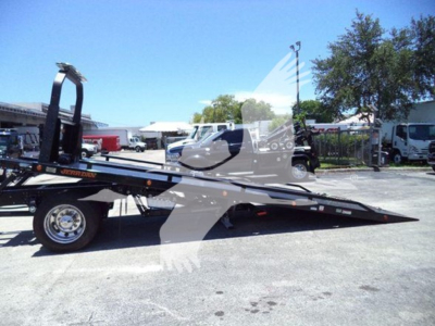 Truck tow rollback bed with hydraulic tilt in profile showing long flatbed and wheel, 2026 Hino L6 listing image.