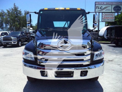 Front view of a 2026 Hino L6 truck in a dealership lot showing chrome grille, bumper, headlights, and windshield; VIN and stock number not visible on image; reflection of surrounding signage.