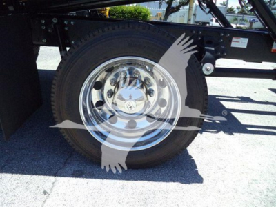 Wheel and tire of a 2026 Hino L6 rollback truck showing chrome hubcap and black tire with vehicle frame and components in the background.