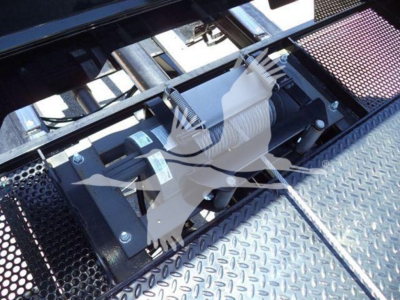 Truck equipment image showing a winch mechanism with a white rope wound around a drum mounted on a diamond plate surface.