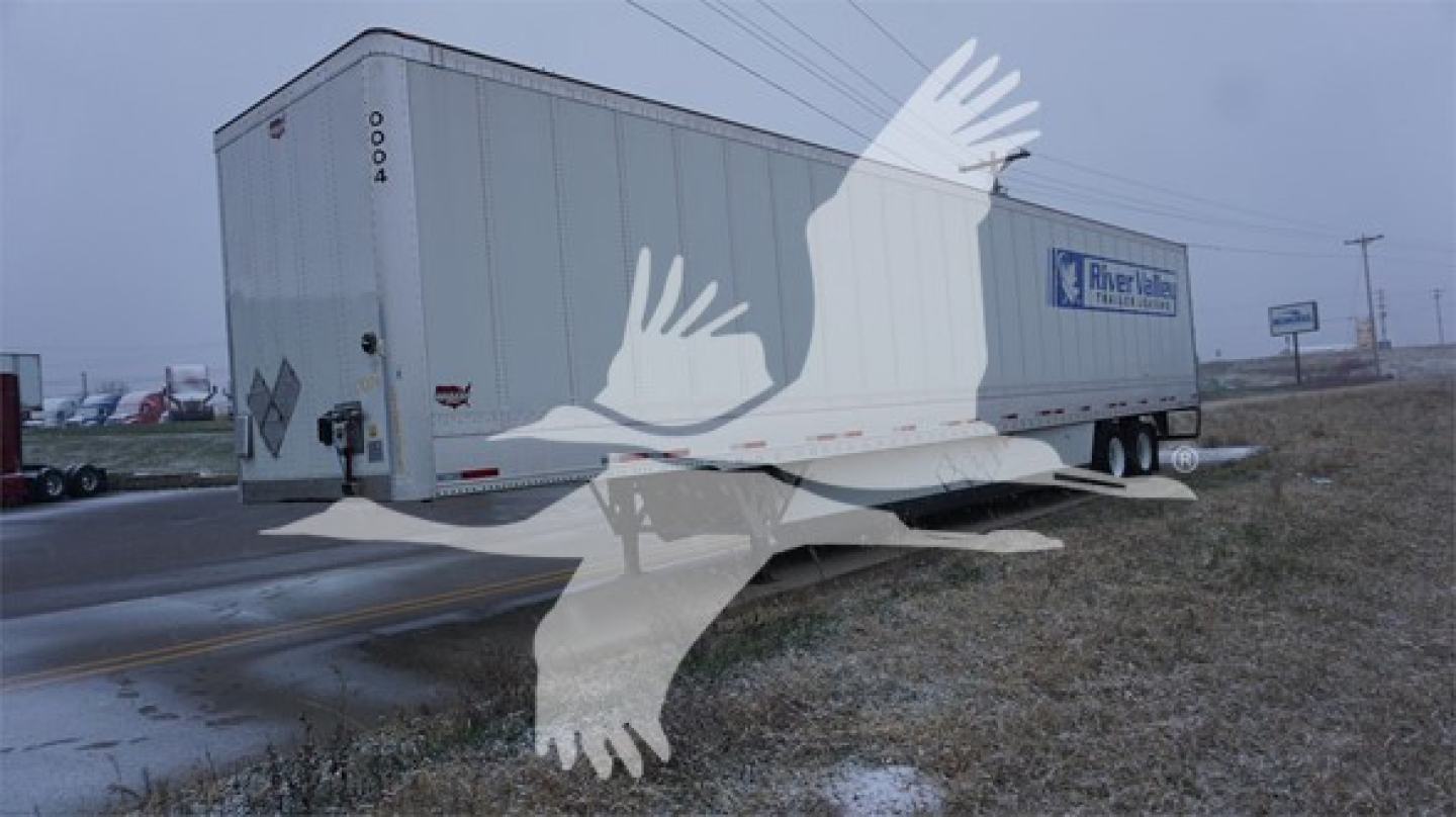 Trailer side and rear showing a Wabash dry van trailer with model number 0004 on rear corner, white with blue logo, and general exterior details.