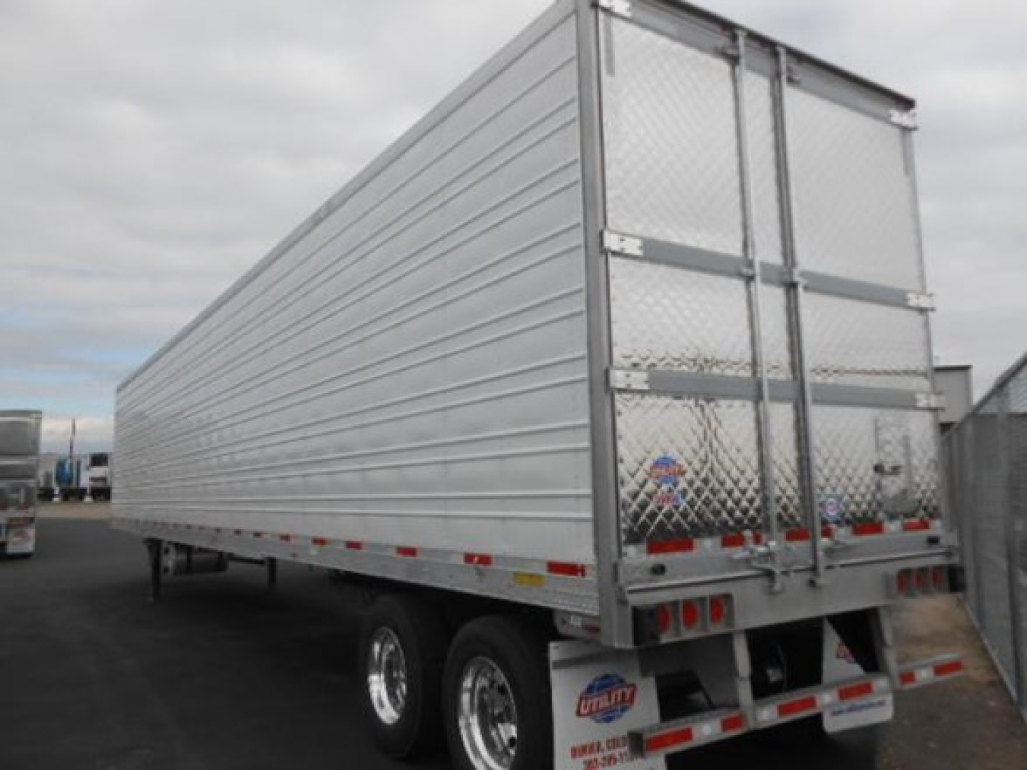 Utility 3000R reefer trailer with aluminum side panels and dual rear doors, silver/metallic finish, on a trailer lot.