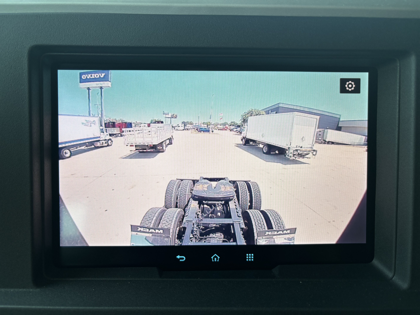 Mack PR64T76H truck cab view from the rear with a trailer hitch and dual rear axles visible in the foreground.