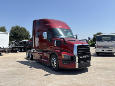 Truck in a dealership lot: red 2027 Mack PR64T76H semi with sleeper cab, front grille, and chrome bumper; VIN 1M1PR4GYXVM103708 visible in listing materials.