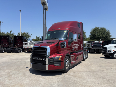 Truck cab in red color with Mack PR64T76H branding, front grille and headlights visible, side mirrors, large sleeper cab, day time outdoor lot.