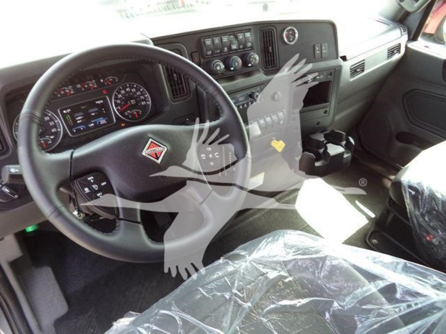 Dashboard and steering wheel of new 2027 International MV truck showing steering wheel with logo and instrument cluster.