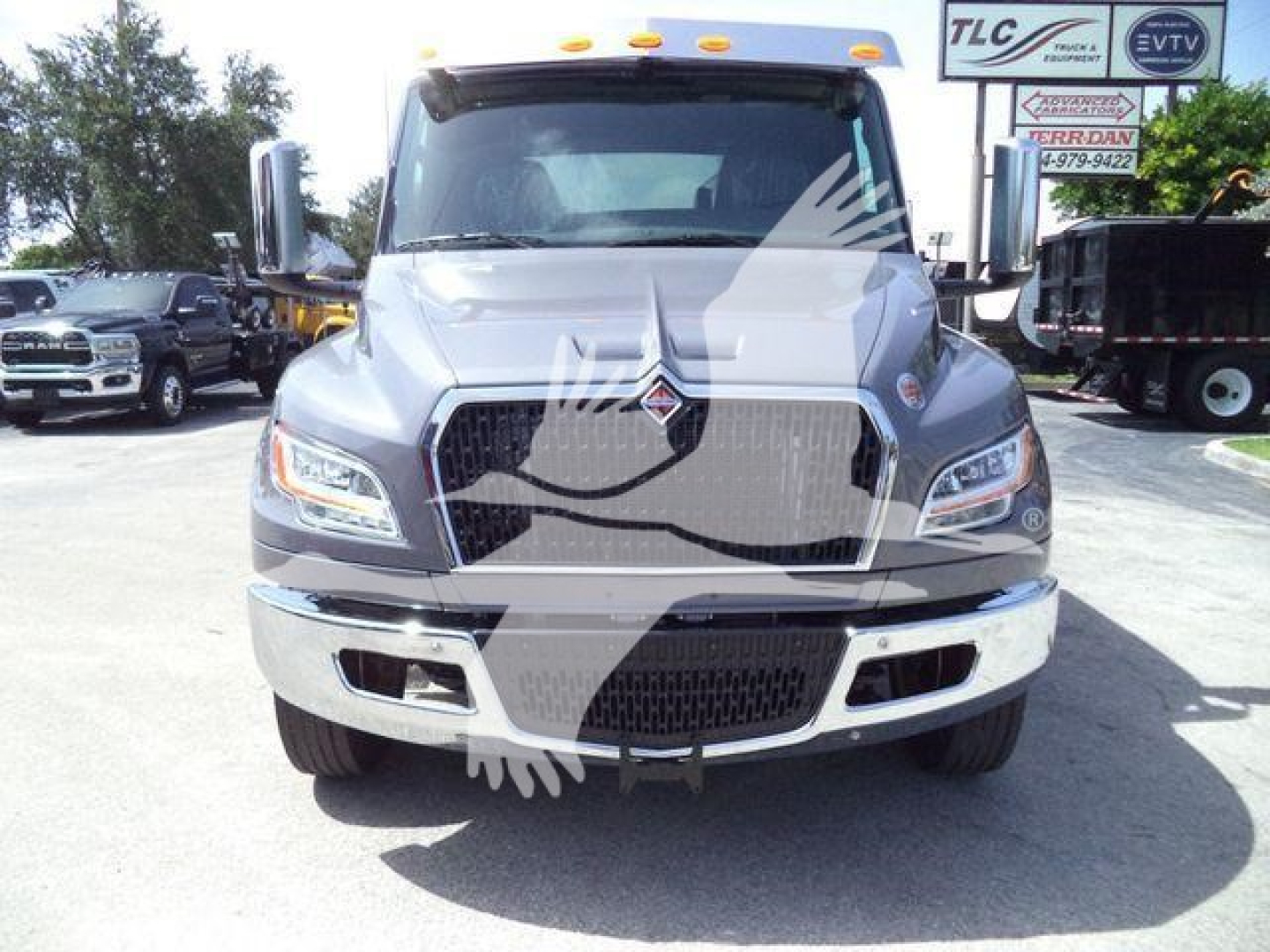 Front view of a white 2027 International MV rollback truck showing chrome grille, LED headlights, and bumper with emblem.