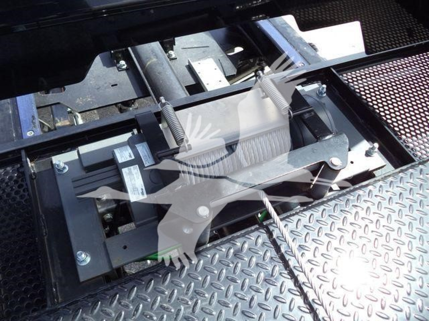 Truck equipment showing rooftop rollback mechanism with metal brackets and springs.