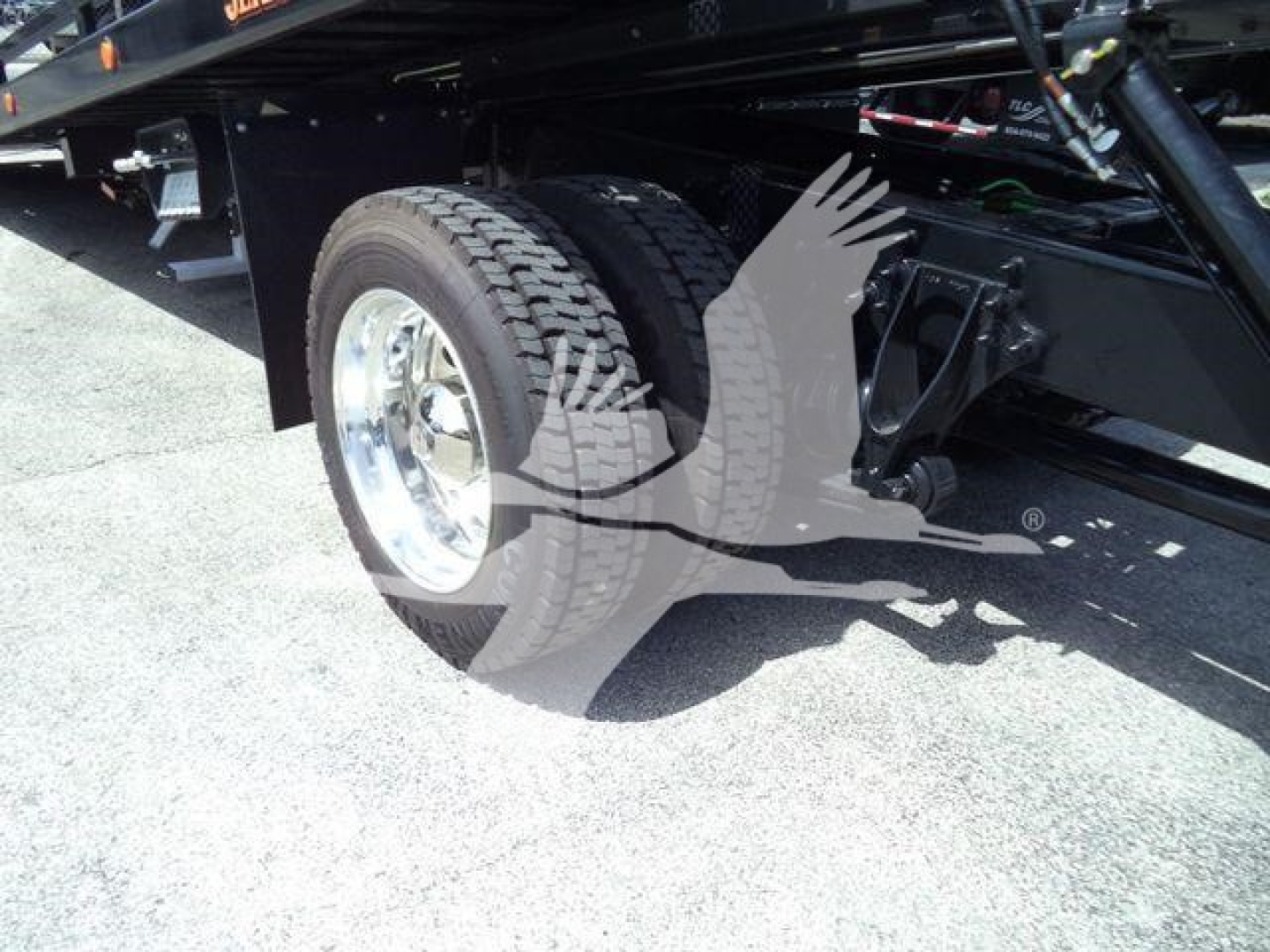 Truck drivetrain area showing rear wheel and suspension on a new International MV rollback truck.