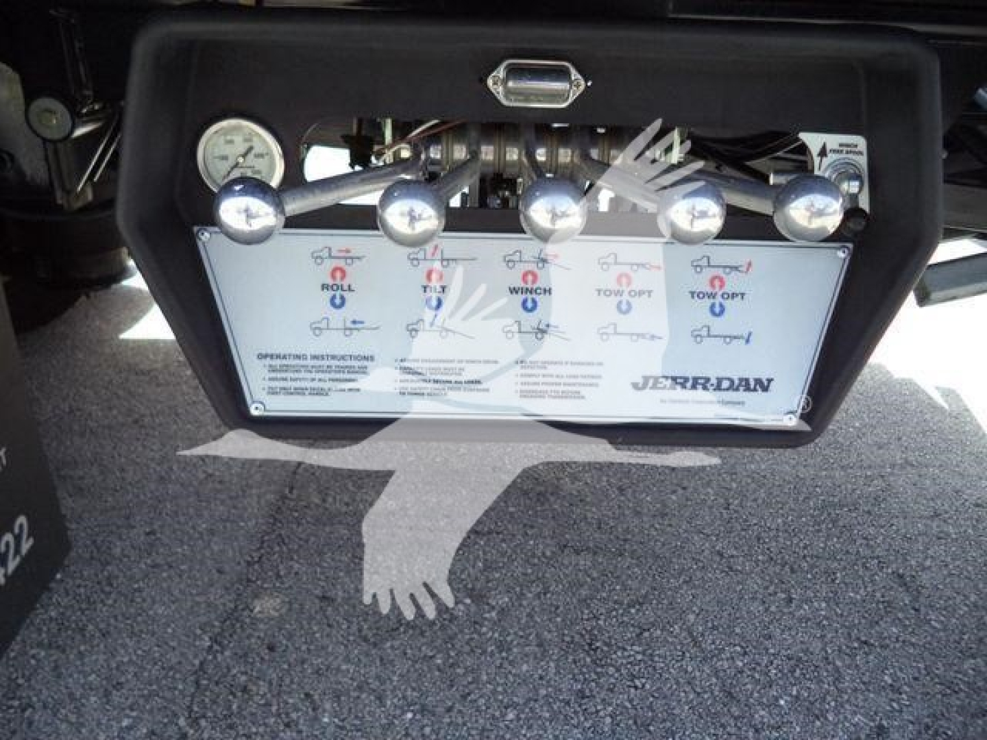 Control panel for a rollback truck showing multiple levers and a panel with labels and the brand Jerr-Dan. Visible text includes various operation indicators and gauges.