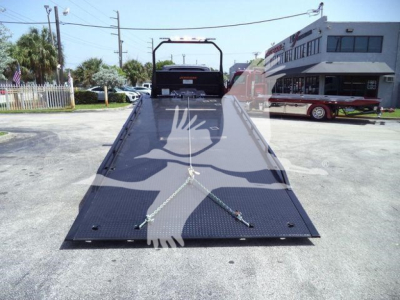 Tow truck rollback bed with chain tie-downs and reflective birds overlay in image of new 2027 International MV, VIN 1HTEUMML0VS478861, stock J78861.