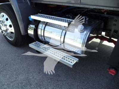 Truck side showing polished aluminum fuel tank with metal steps (side steps) and wheel in background.
