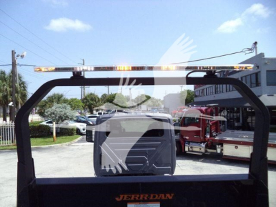 Truck accessory rear frame with JERR-DAN logo on rear platform, overhead clearance bar, and partial truck cab in distance.