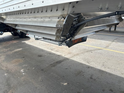 Fract sand hopper trailer underside showing TIMPTE branding and welded steel frame with hydraulic hinge arm.