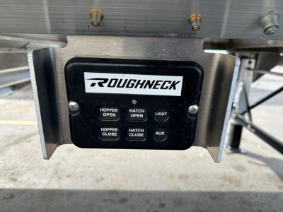 Roughneck control panel on underside of a hopper trailer with buttons labeled Hopper Open, Hopper Close, Hatch Open, Hatch Close, Light, Aux.