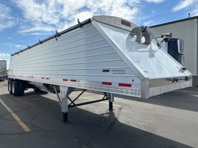 Frac sand hopper trailer by Timpte showing aluminum silvery body and triangular hitch, dual axle, reflective tape along sides.