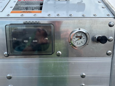 Timpte frac sand hopper trailer control panel showing Open/Close switch, pressure gauge, and label. visible labels include warning sticker and model info on metal panel.