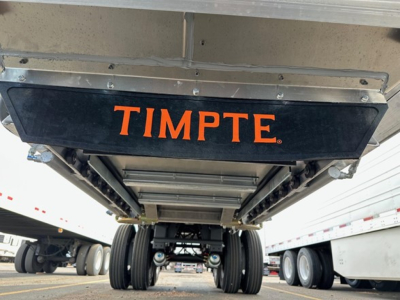 Timpte hopper trailer undercarriage view showing Timpte logo plate and wheel axles.