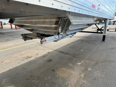 Framed underside view of a Timpte frac sand hopper trailer showing dual leg jack and silver structural components with a tank or auger system.