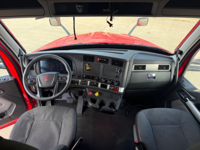 Kenworth T680 cabin interior view with steering wheel, dashboard, and two seats visible; center console shows controls and gauges.