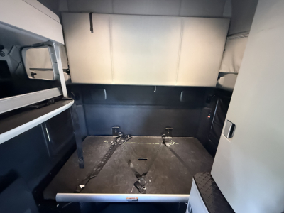 Kenworth T680 sleeper cab interior cargo area showing open storage and metallic floor panel with tie-downs.