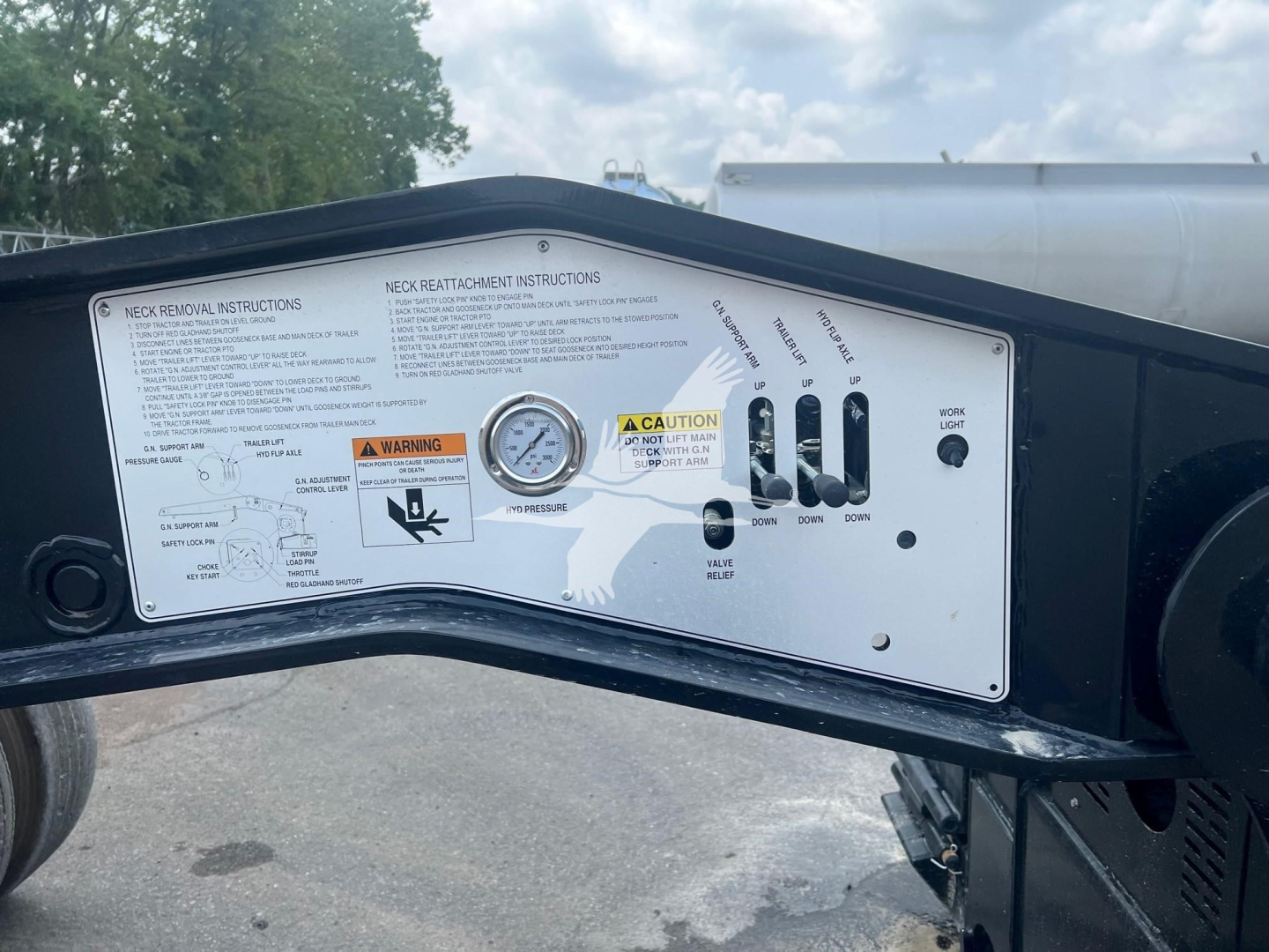 Trailer control panel with instructions, gauges, and labeled dials on XL Specialized XL110HGS lowboy trailer side showing operation labels and handles.
