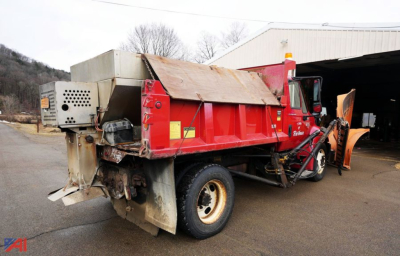 2004 International 4200 dump truck with plow and spreader, red body, front plow attachment, side hopper, and service area at rear.