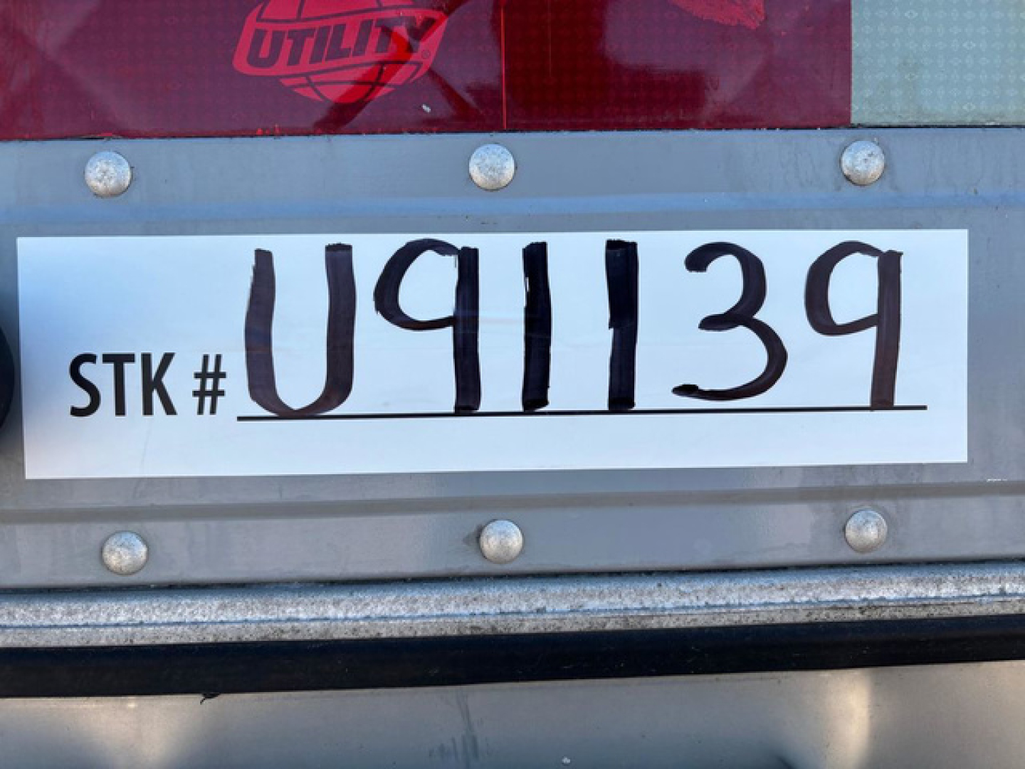 STK # U91139 sign on trailer with large handwritten U91139 and printed STK # on white label.