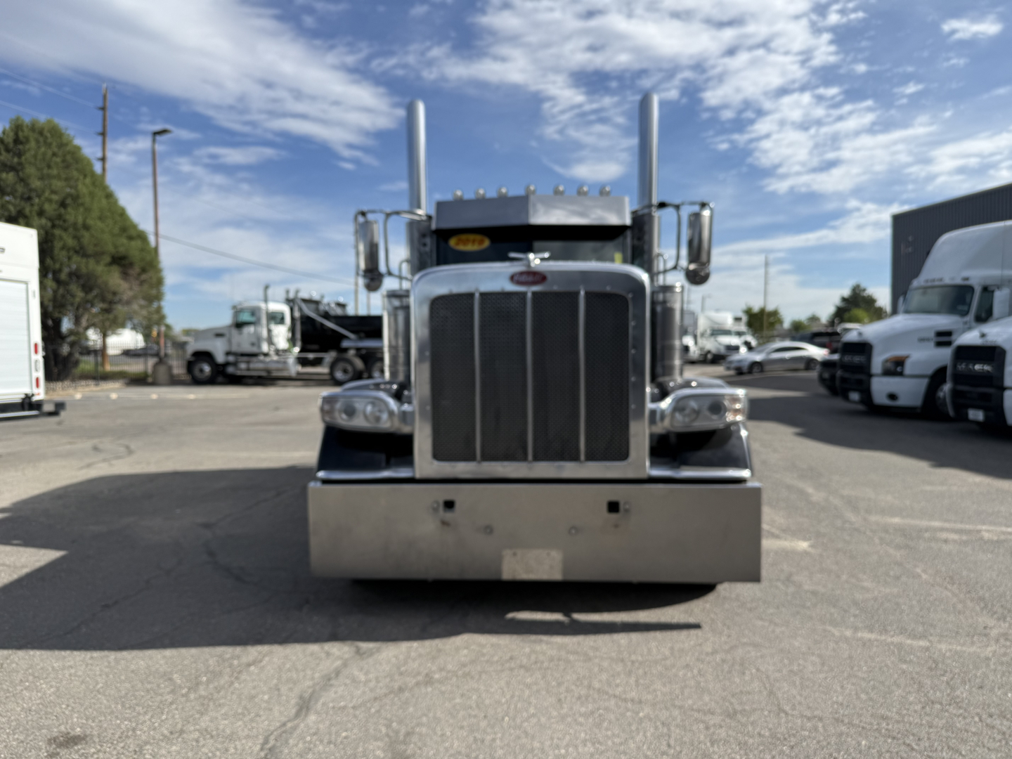 Front view of a 2019 Peterbilt 389 truck showing its chrome grille and bumper.