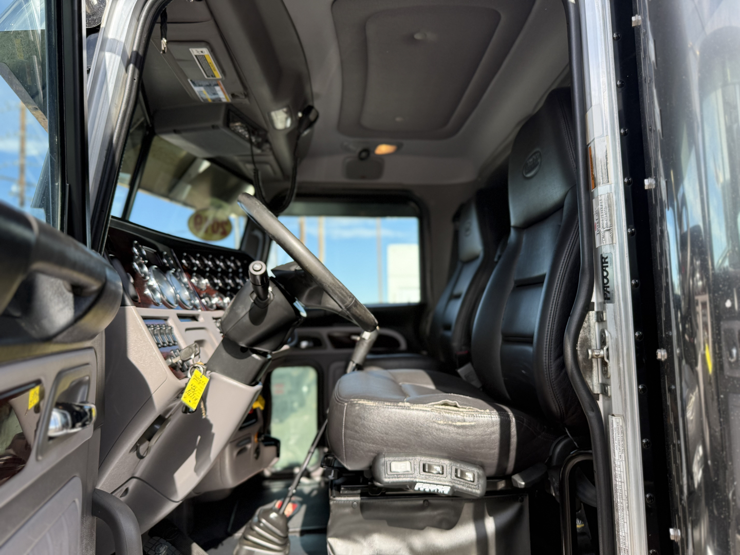 Peterbilt 389 truck interior cab view showing steering column, dashboard gauges, and driver seat with controls.