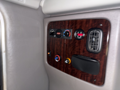 Peterbilt dash panel view with wood grain trim showing gauges and controls in cab interior.