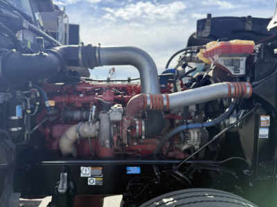Peterbilt 389 engine bay showing red diesel engine with silver intercooler piping and yellow expansion tank