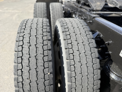 Peterbilt 389 truck rear showing dual rear axles with treaded tires and wheel rims.
