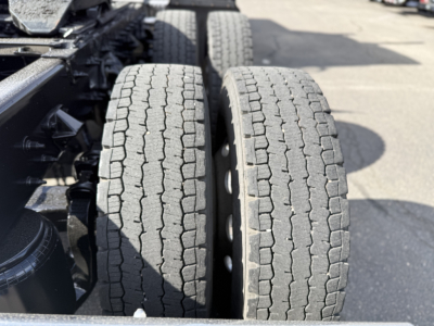 Two rear dual tires on a Peterbilt truck chassis with nearby components visible in the engine bay area.