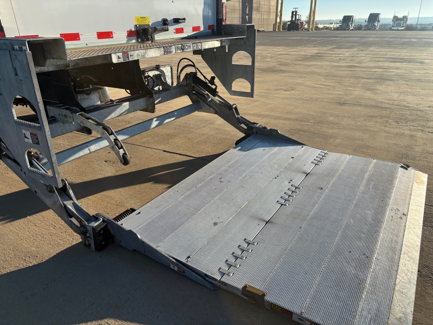 Freightliner M2-106 loading ramp at rear showing aluminum platform and hydraulic components.