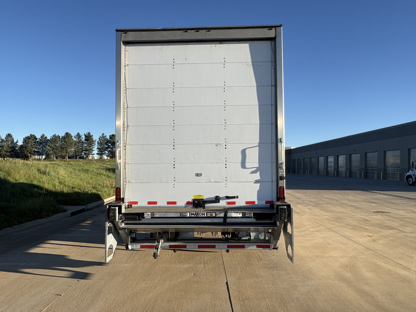 Freightliner M2-106 rear view showing large box cargo area and rear bumper with reflective tape.