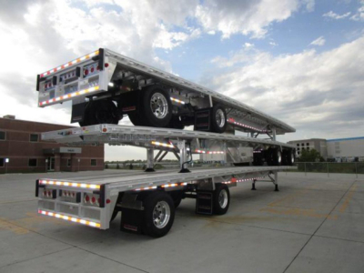 Tow trailer stack with two flatbeds and wheels, aluminum alloy, rear deck showing reflective lights and taillights.